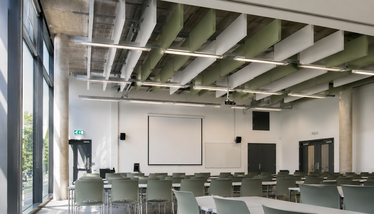 Pannello per soffitto in una sala riunioni con tavolo lungo e sedie ergonomiche