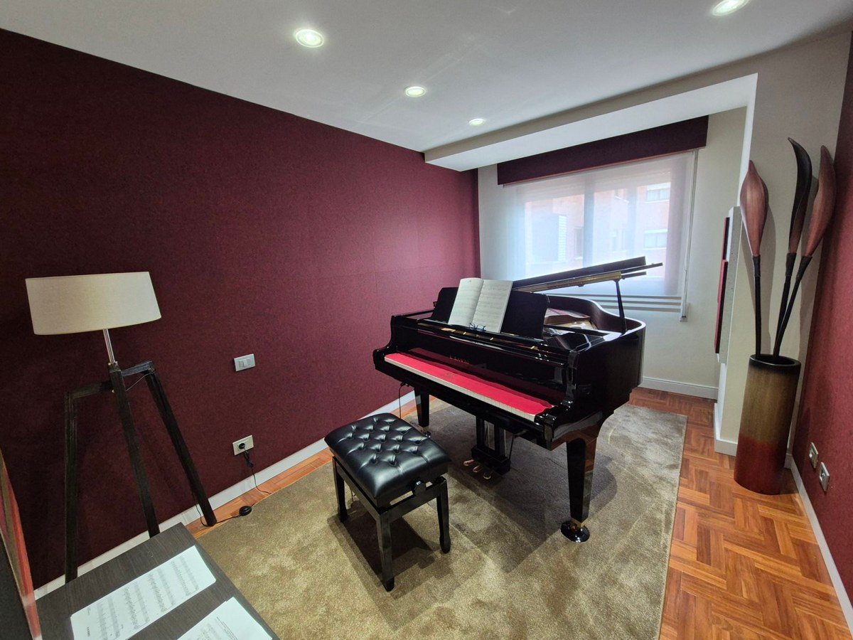Parete acustica Bilnora in una sala con pianoforte a coda, dove il feltro crea uno sfondo sobrio e raffinato