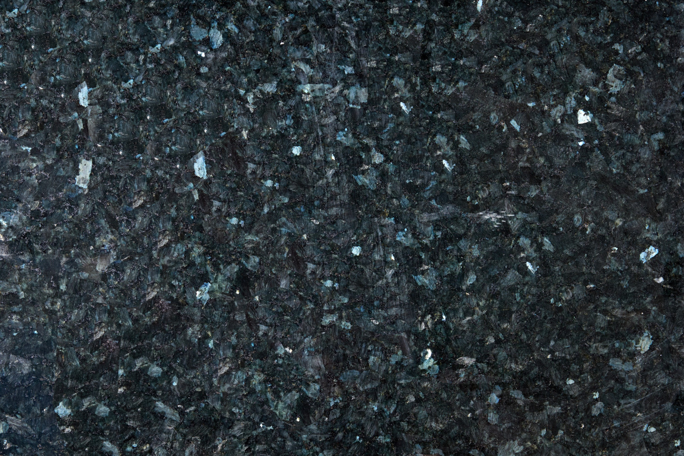 Lastra in vero granito Blue Pearl vista in primo piano, con superficie scura dai riflessi blu-grigio e cristalli minerali iridescenti ben visibili.