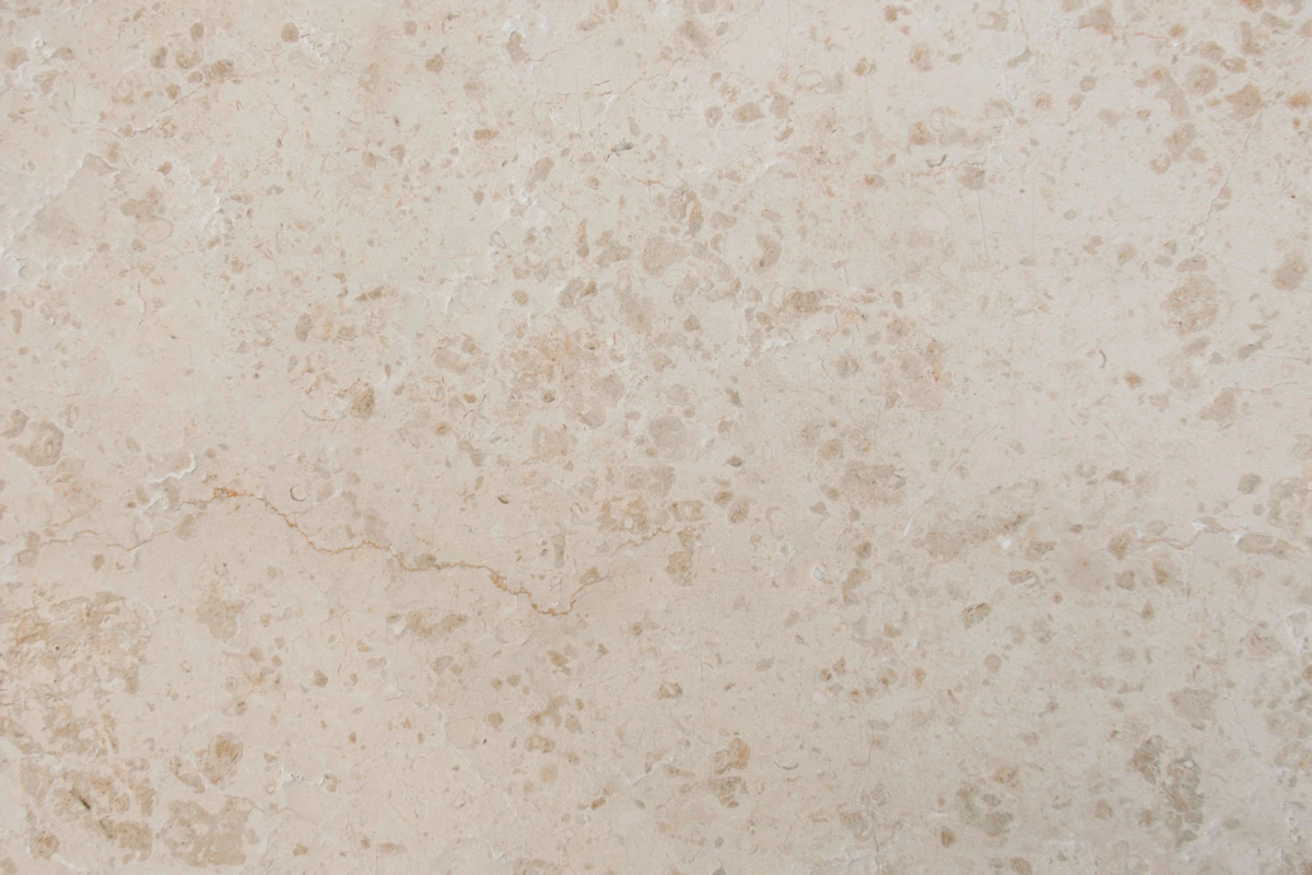 Lastra in vera pietra calcarea Kanafar in tonalità beige chiaro, con leggere venature e inclusioni fossili naturali ben evidenti sulla superficie.