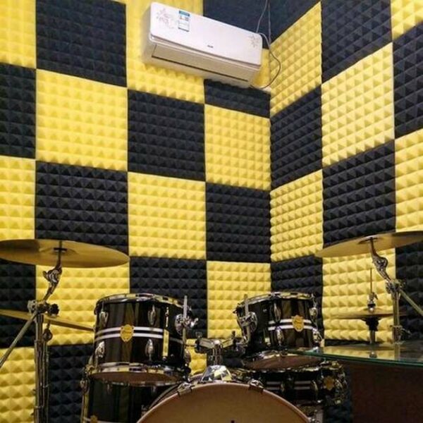 tromba acustica gialla e nera a cancellazione di rumore in uno studio di batteria